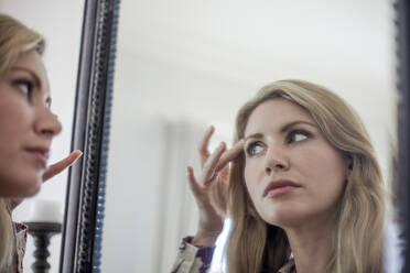 Woman checking make up in a mirror - AJOF00044