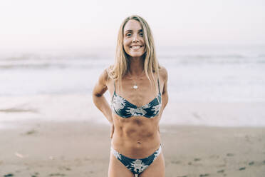 Junge blonde Frau im Bikini am Strand - MTBF00120