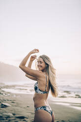 Junge blonde Frau im Bikini am Strand - MTBF00121
