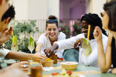 Glückliche multiethnische Freunde, die sich auf einer Party amüsieren und gemeinsam essen - SODF00161
