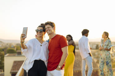 Junge Frau und Mann machen ein Selfie während einer Party am Abend - SODF00175