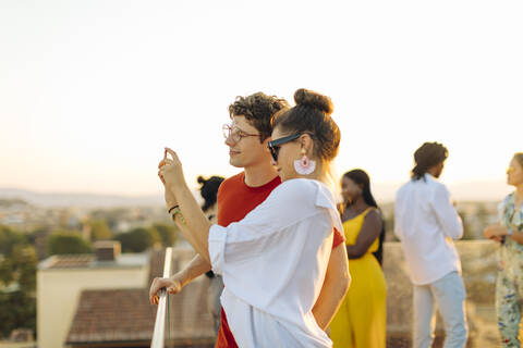 Junge Frau und Mann machen ein Selfie während einer Party am Abend, lizenzfreies Stockfoto