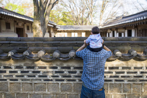 Rückenansicht des Vaters und des kleinen Mädchens beim Besuch des Secret Garden, Changdeokgung, Seoul, Südkorea - GEMF03265