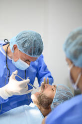 Dentist surgeon injecting anesthesia to patient - OCMF00868