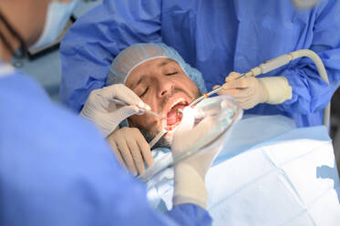 Dentist doctor performing a patient implant - OCMF00870