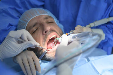 Dentist doctor performing a patient implant - OCMF00871