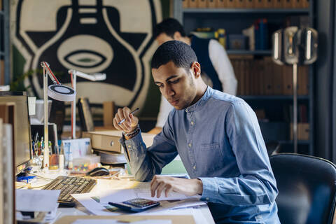 Junger Mann arbeitet in einem Architekturbüro, lizenzfreies Stockfoto