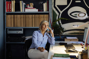 Mature woman working in architct's office, talking on the phone - SODF00210