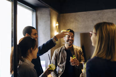 Colleagues celebrating after work in a bar - SODF00275