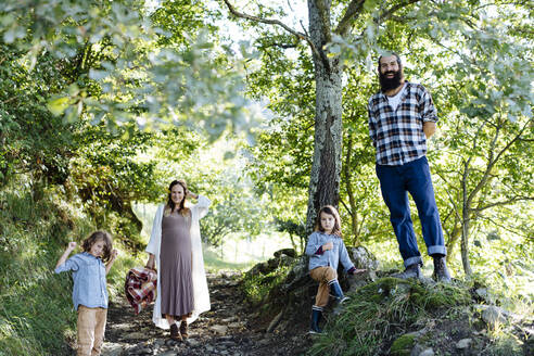 Portait einer glücklichen Familie mit zwei Kindern im Wald - SODF00342