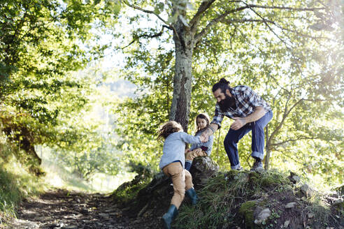 Junge greift im Wald nach der Hand des Vaters - SODF00343