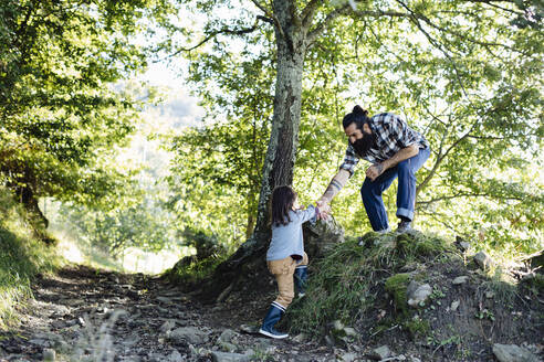 Junge greift im Wald nach der Hand des Vaters - SODF00344