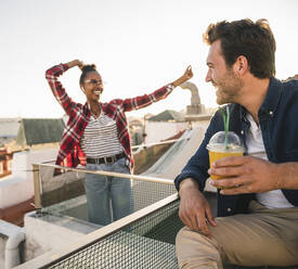 Happy young couple having a rooftop party - UUF19450