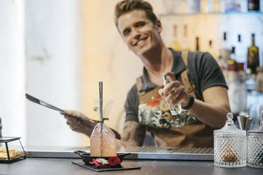 Barkeeper beim Mixen eines Cocktails in einer Bar, Cocktail im Beutel - MTBF00152