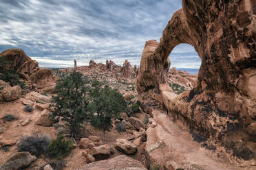 Scenic view of rock formations at Arches National Park against cloudy sky - CAVF68263