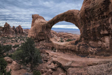 Rock formations at Arches National Park against cloudy sky - CAVF68264
