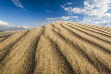 Landschaftliche Ansicht einer Sanddüne am Strand gegen blauen Himmel - CAVF68272