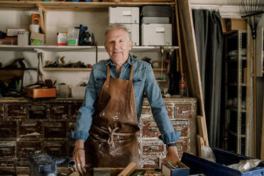 Porträt eines zuversichtlich lächelnden älteren männlichen Besitzers in einer Werkstatt - MASF14017