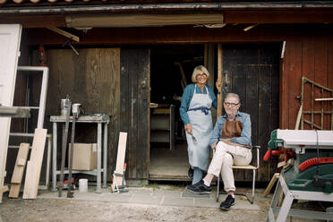 Full length portrait of smiling senior coworkers at hardware store entrance - MASF14037