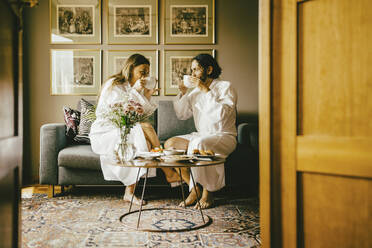 Couple in bathrobes drinking coffee while enjoying breakfast at hotel - MASF14126