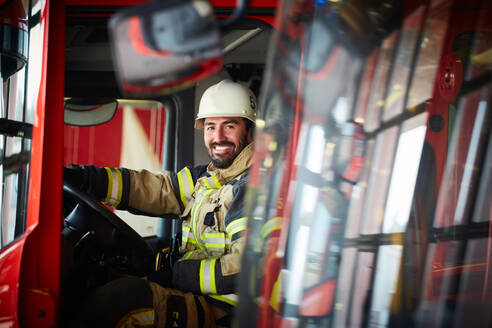 Porträt eines erwachsenen Feuerwehrmanns im Feuerwehrauto auf der Feuerwache - MASF14180