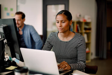 Geschäftsfrau, die am Schreibtisch über ihren Laptop nachdenkt - MASF14241