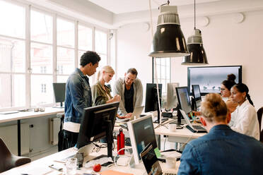 Creative business people working on computers in open plan office - MASF14276