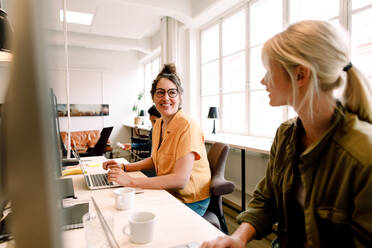 Smiling businesswoman talking with mid adult colleague in office - MASF14296