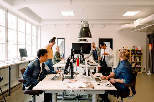 Kreative männliche und weibliche Geschäftskollegen arbeiten in einem Großraumbüro - MASF14298