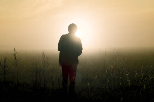 Silhouette Mann stehend auf Feld gegen Himmel - CAVF68422