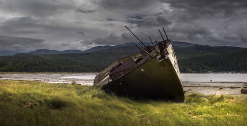 Rainbow and beached old wooden fishing boats on shore at Salen Stock Photo  by Mint_Images