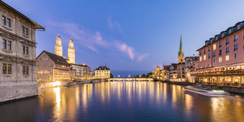 Schweiz, Kanton Zürich, Zürich, Fluss Limmat zwischen beleuchteten Altstadthäusern am Wasser in der Abenddämmerung - WDF05562