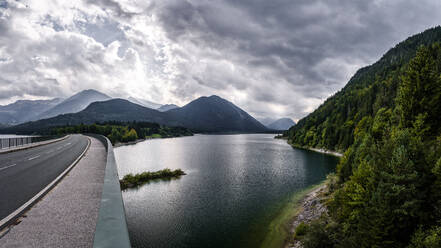 Deutschland, Bayern, Bewölkter Himmel über der Autobahn, die den Sylvenstein-Stausee überquert - STSF02333