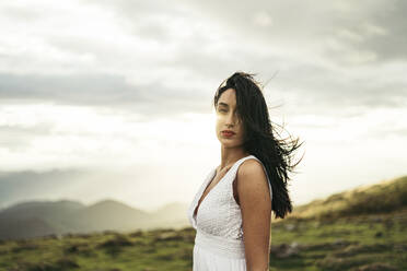 Young woman wearing white dress on viewpoint at sunset - MTBF00160