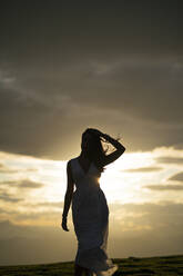 Young woman wearing white dress at sunset - MTBF00167