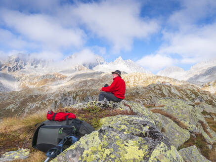 Wanderer sitzt auf einem Berg und genießt die Aussicht, Naturpark Adamello, Italien - LAF02406