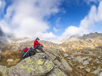 Wanderer sitzt auf einem Berg und genießt die Aussicht, Naturpark Adamello, Italien - LAF02408