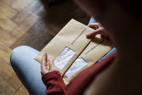 Female elector holding documtents for the postal vote in her hands - MAMF00954