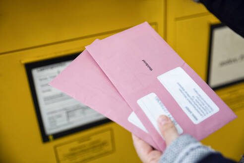 Wähler mit Briefwahlunterlagen vor dem Briefkasten - MAMF00955