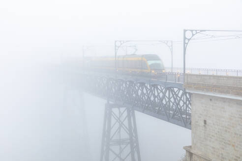 Straßenbahn auf der Luiz-I-Brücke, die aus dem Nebel auftaucht, Porto, Portugal - WPEF02266
