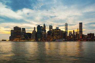 USA, New York, New York City, Manhattan skyline illuminated at dusk - GIOF07562