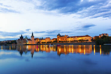 Czech Republic, Prague, City skyline illuminated at dusk seen across river - GIOF07582