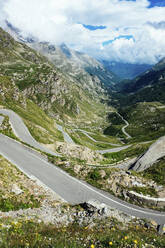 Italien, Piemont, Blick von oben auf eine lange, kurvenreiche Straße im Gran Paradiso National Park - GIOF07607