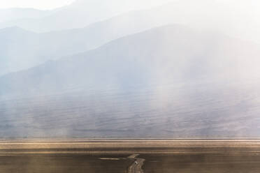 USA, California, Dust floating over dirt road in Death Valley - GIOF07630