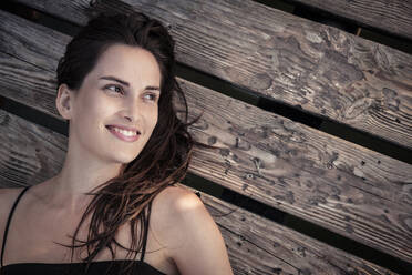 Porträt einer lächelnden jungen Frau, die sich auf einem Bootssteg entspannt - WFF00162