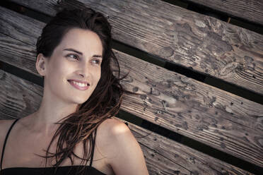 Portrait of smiling young woman relaxing on jetty - WFF00162