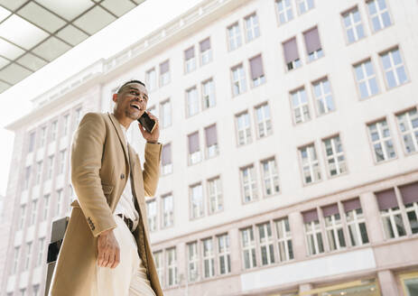 Porträt eines lachenden Geschäftsmannes am Telefon - AHSF01116