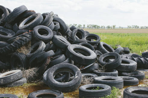 Stapel ausrangierter Autoreifen, Ackerland in der Ferne, in der Nähe von Cimarron, Kansas - MINF12688