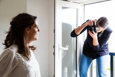 A professional make up artist at work, taking photograph of woman. - MINF12748