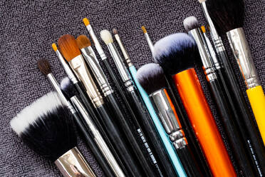 High angle close up of a selection of make-up brushes in various shapes ad sizes. - MINF12752